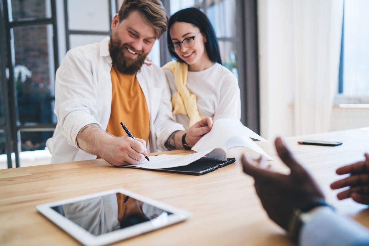 Couple signing FHA mortgage paperwork for a home in Royal Oak, Michigan